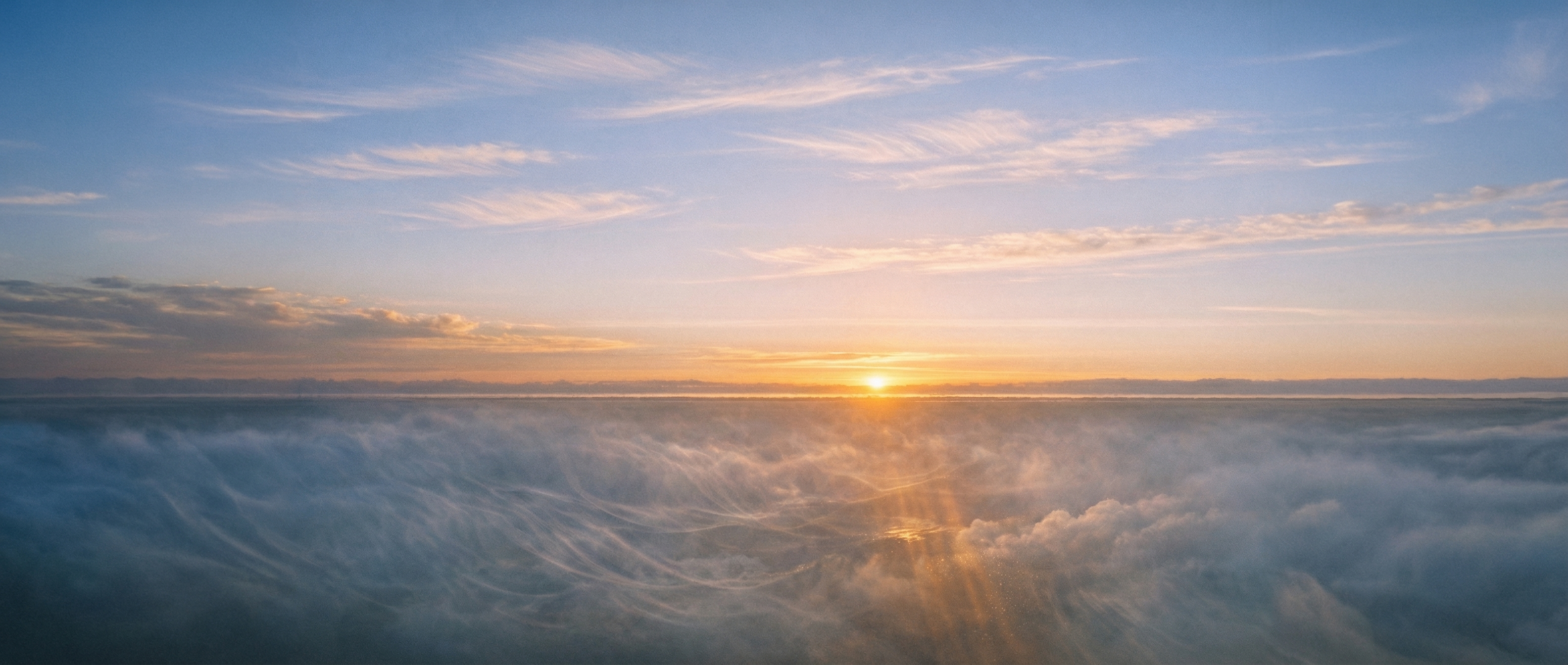 Atmospheric cross-section at dawn showing stable upper cloud layers illuminated by warm light above turbulent, shadowed thermal currents below - two atmospheric systems operating simultaneously.